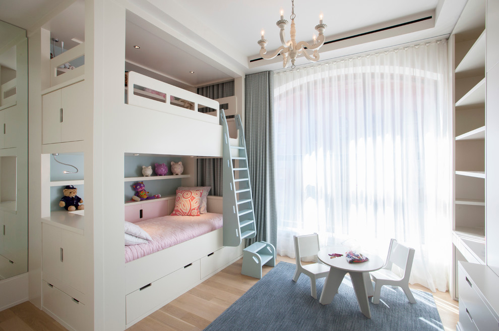 Exempel på ett mellanstort klassiskt flickrum kombinerat med sovrum och för 4-10-åringar, med vita väggar och ljust trägolv