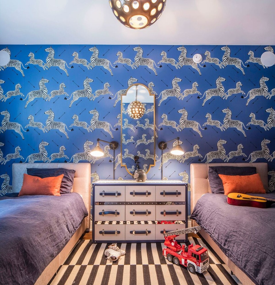 Klassisk inredning av ett mellanstort pojkrum kombinerat med sovrum och för 4-10-åringar, med blå väggar, mellanmörkt trägolv och brunt golv