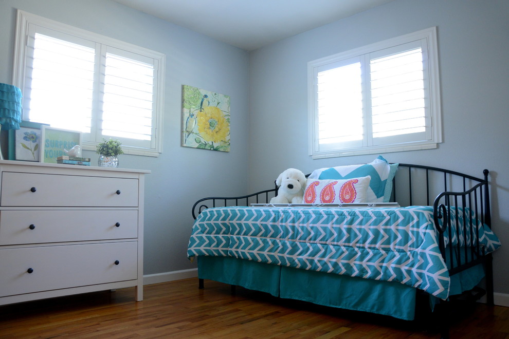 Inspiration för små moderna barnrum kombinerat med sovrum, med blå väggar, mellanmörkt trägolv och brunt golv