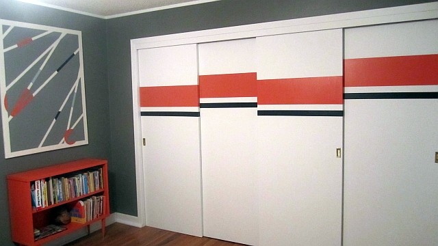Cette image montre une chambre d'enfant minimaliste avec un mur gris et un sol en bois brun.