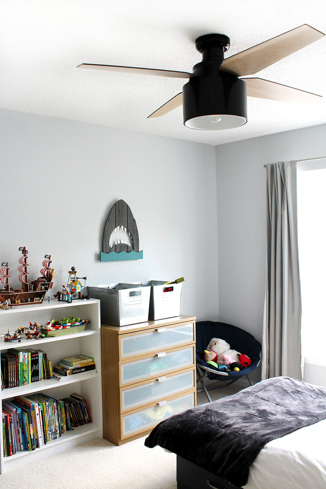 Inredning av ett modernt mellanstort pojkrum kombinerat med sovrum och för 4-10-åringar, med blå väggar, heltäckningsmatta och beiget golv