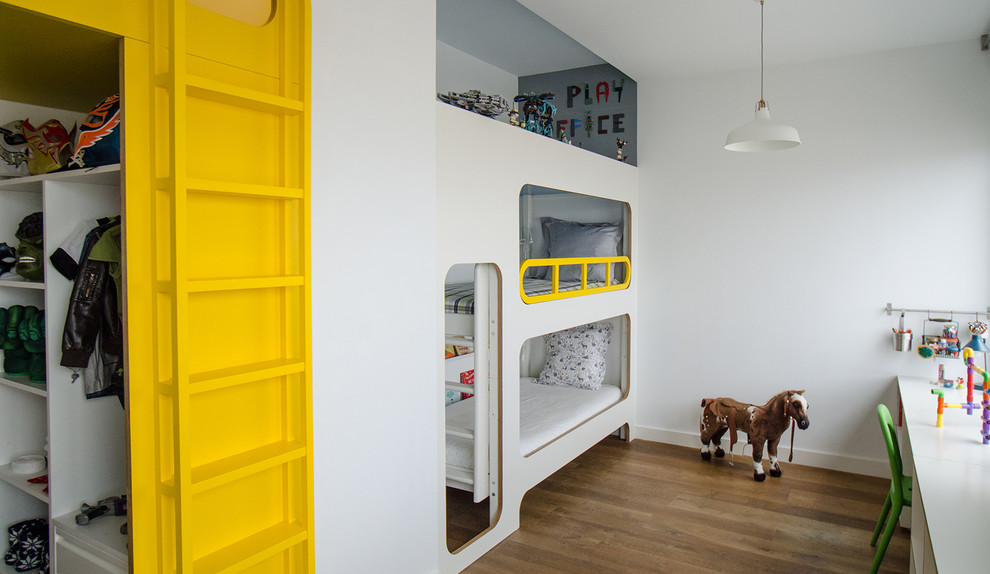 Immagine di una cameretta per bambini da 4 a 10 anni minimal di medie dimensioni con pareti bianche e pavimento in legno massello medio