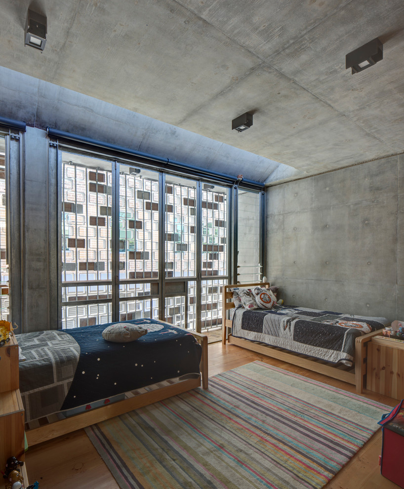 Exemple d'une chambre d'enfant de 4 à 10 ans industrielle avec un mur gris, un sol en bois brun et un sol beige.