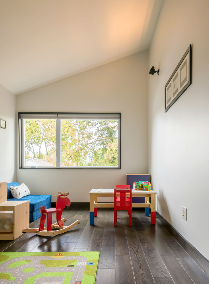 Exemple d'une chambre d'enfant de 1 à 3 ans scandinave avec un mur blanc et parquet foncé.