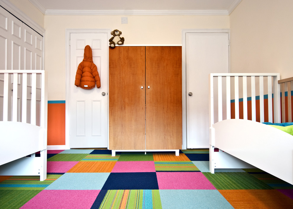 Immagine di una cameretta per bambini da 1 a 3 anni contemporanea con moquette, pavimento multicolore e pareti arancioni