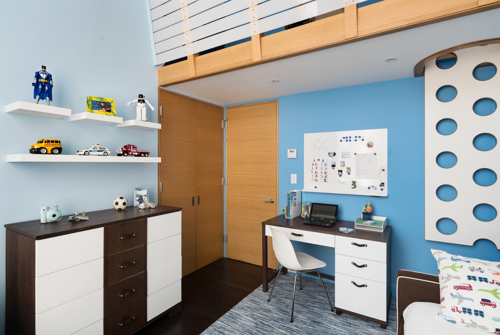 Exempel på ett mellanstort modernt pojkrum för 4-10-åringar och kombinerat med skrivbord, med blå väggar och mörkt trägolv