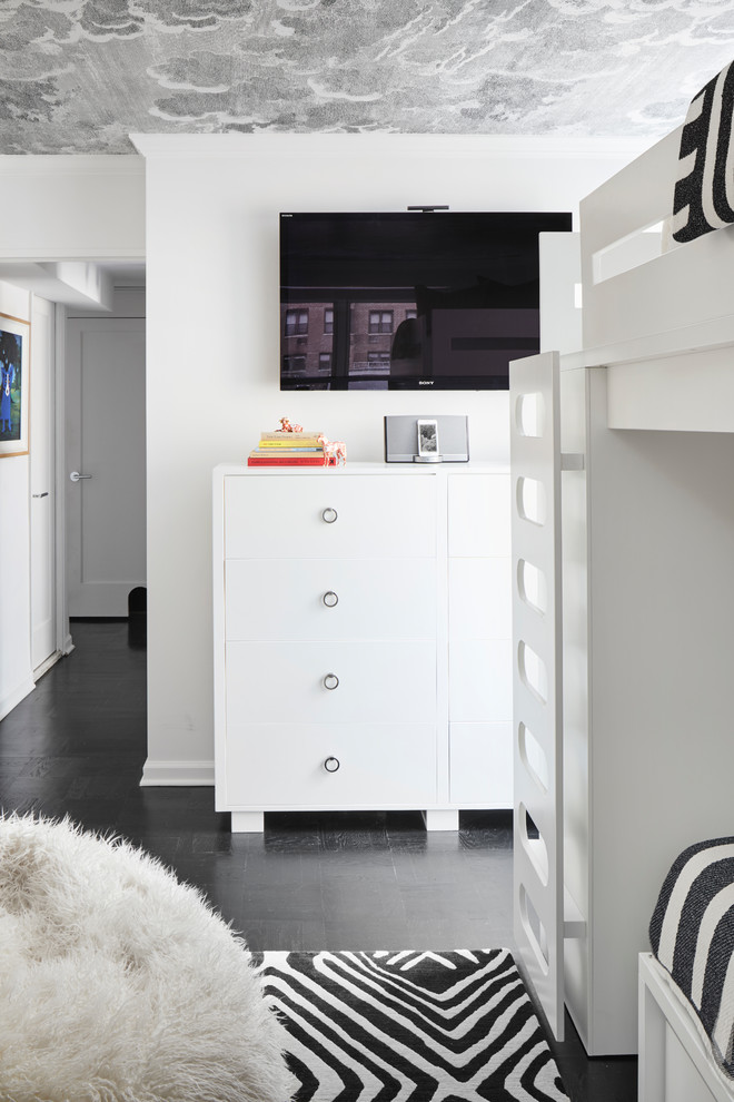 Example of a small minimalist gender-neutral dark wood floor and black floor kids' room design in New York with white walls
