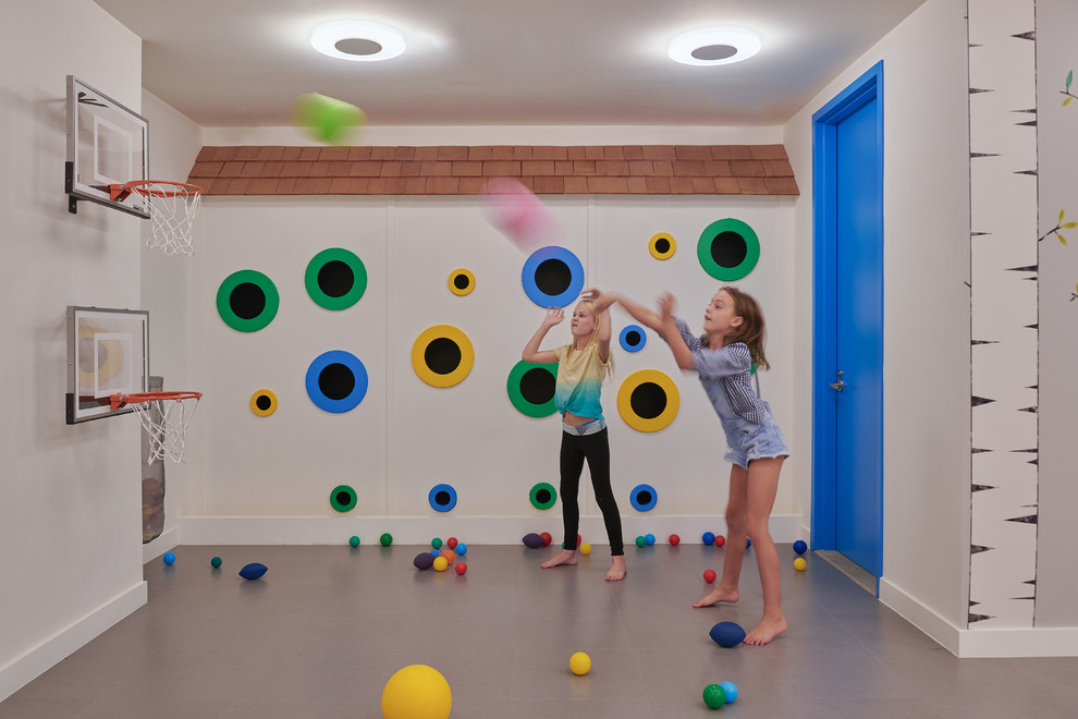 Modern inredning av ett mellanstort könsneutralt barnrum kombinerat med lekrum, med vita väggar, vinylgolv och grått golv