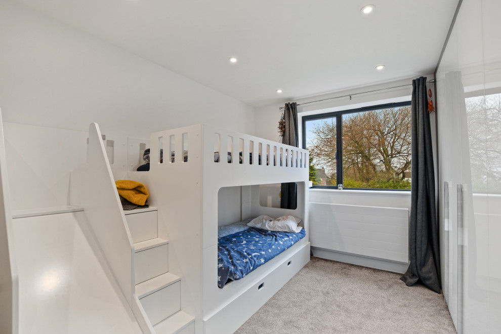 Photo of a medium sized contemporary children’s room for boys in London with white walls, carpet and grey floors.