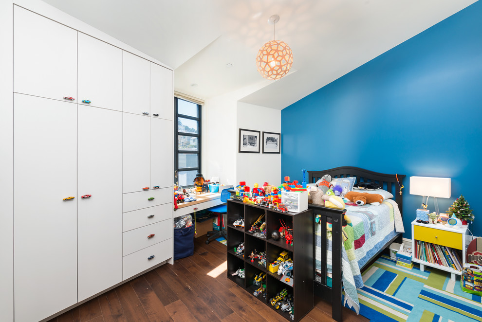 Immagine di una grande cameretta per bambini da 1 a 3 anni minimal con parquet scuro e pareti multicolore