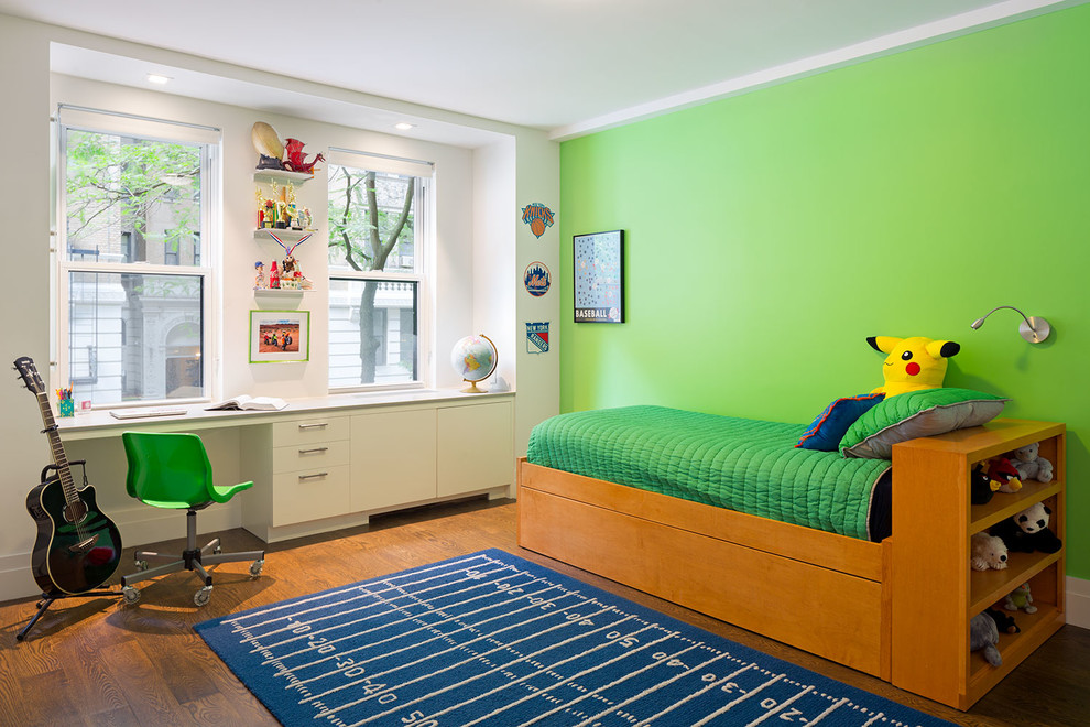 Exempel på ett stort modernt barnrum kombinerat med sovrum, med gröna väggar, mörkt trägolv och brunt golv