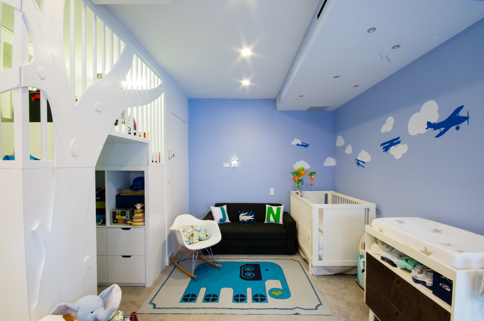 Bild på ett mellanstort funkis pojkrum kombinerat med sovrum, med blå väggar och heltäckningsmatta