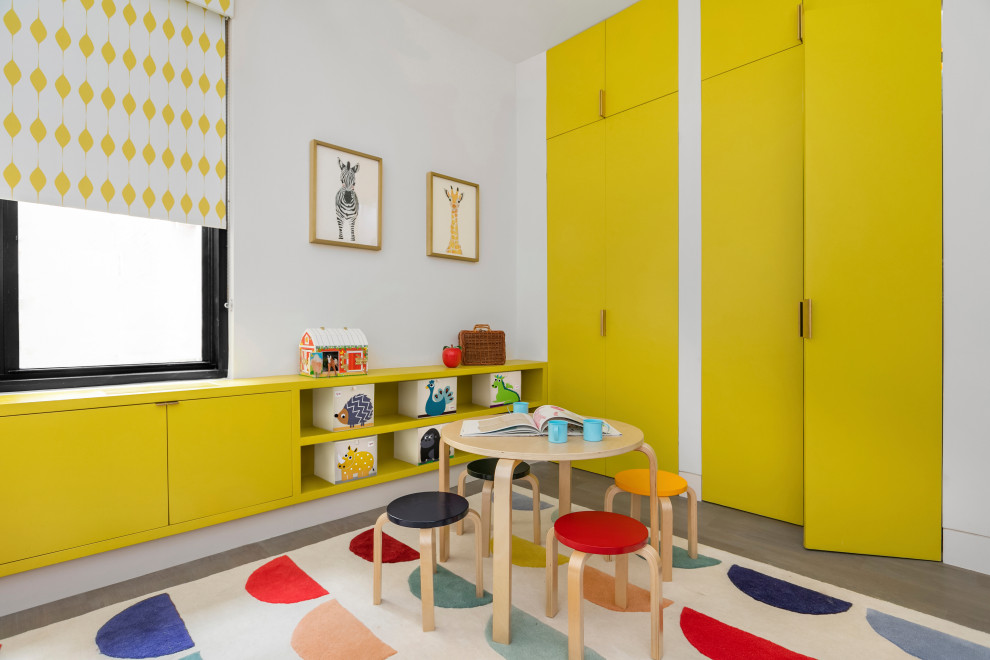 Foto på ett funkis könsneutralt småbarnsrum kombinerat med lekrum, med vita väggar, mellanmörkt trägolv och brunt golv
