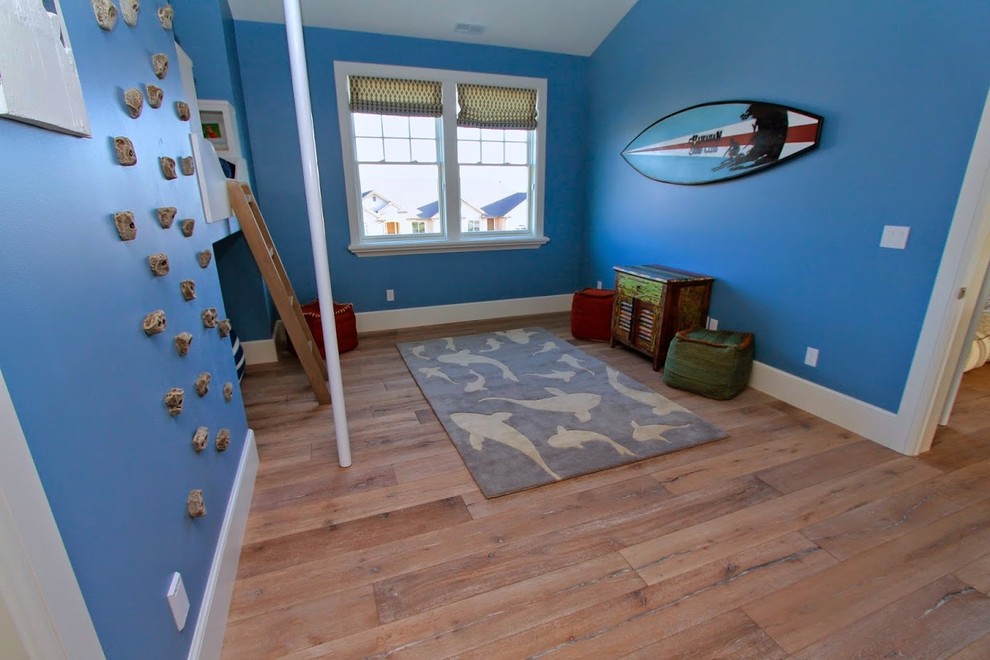 Aménagement d'une grande chambre d'enfant de 4 à 10 ans bord de mer avec un mur bleu et parquet clair.