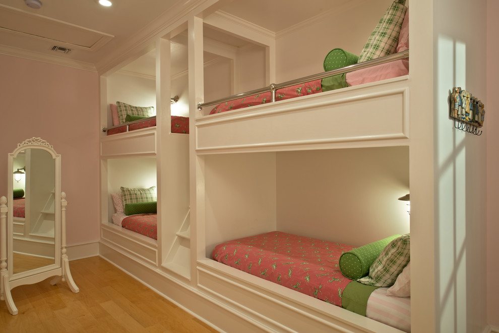 Diseño de dormitorio infantil de 4 a 10 años clásico de tamaño medio con paredes rosas y suelo de madera clara
