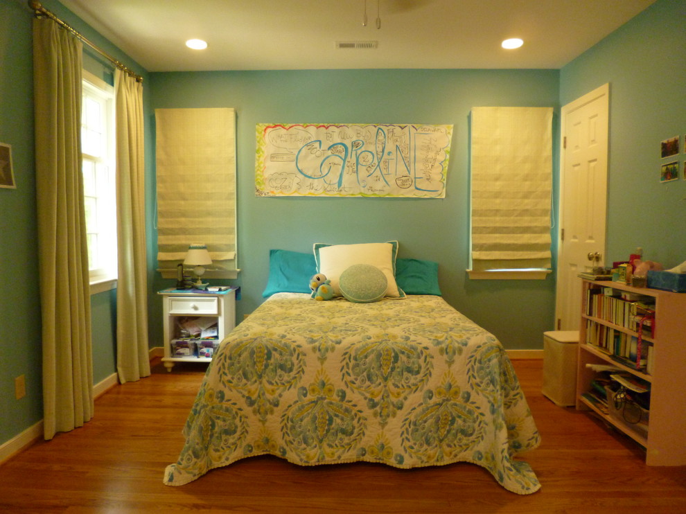 Exempel på ett mellanstort klassiskt barnrum kombinerat med sovrum, med blå väggar, mellanmörkt trägolv och brunt golv