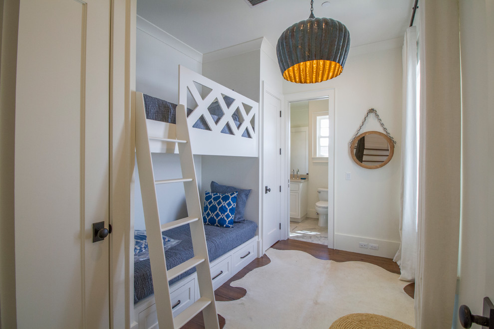 Cette image montre une chambre d'enfant marine avec un mur blanc et parquet foncé.