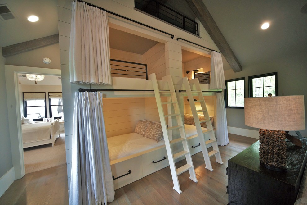 Modelo de dormitorio infantil de 4 a 10 años campestre grande con paredes blancas y suelo de madera en tonos medios