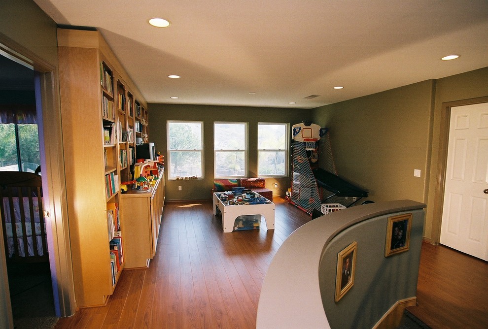 Cette image montre une chambre d'enfant traditionnelle de taille moyenne avec un mur vert et un sol en bois brun.