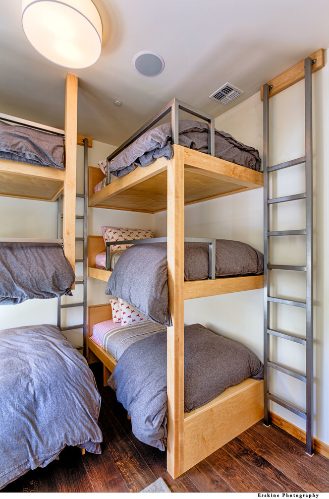 Idéer för mellanstora funkis könsneutrala barnrum kombinerat med sovrum och för 4-10-åringar, med vita väggar, mellanmörkt trägolv och brunt golv