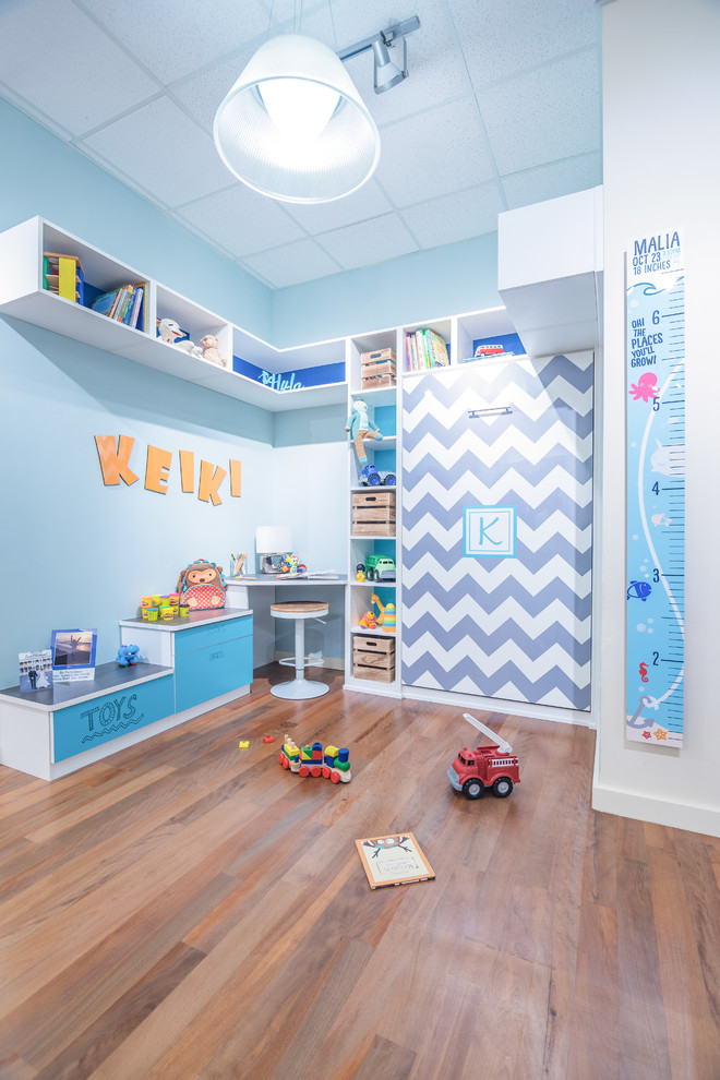 Idée de décoration pour une petite chambre d'enfant de 4 à 10 ans design avec un mur bleu, un sol en bois brun et un sol marron.