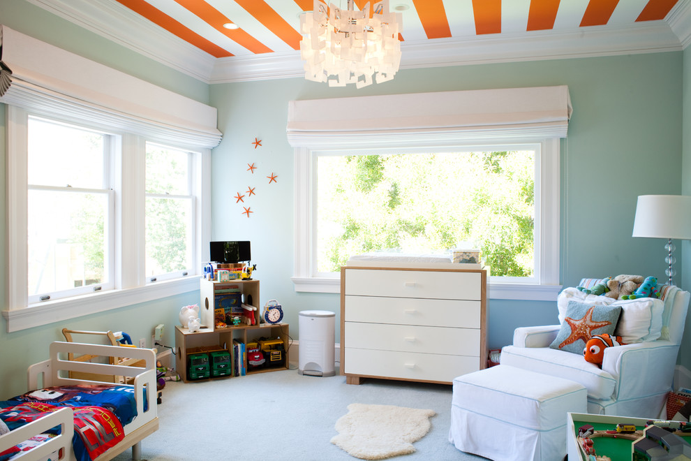 На фото: нейтральная детская в современном стиле с спальным местом, синими стенами, ковровым покрытием и белым полом для ребенка от 1 до 3 лет с