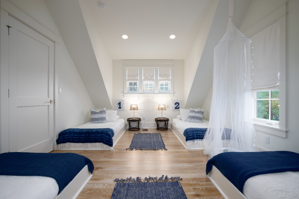 Ejemplo de dormitorio infantil costero con paredes blancas, suelo de madera clara y suelo beige