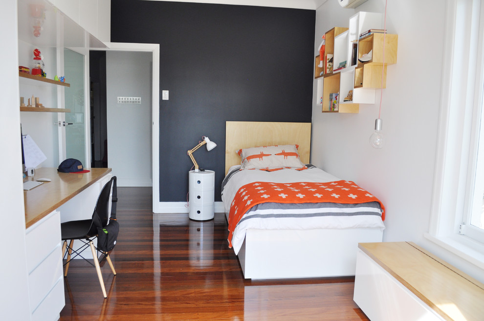 Medium sized contemporary teen’s room for boys in Brisbane with medium hardwood flooring and black walls.