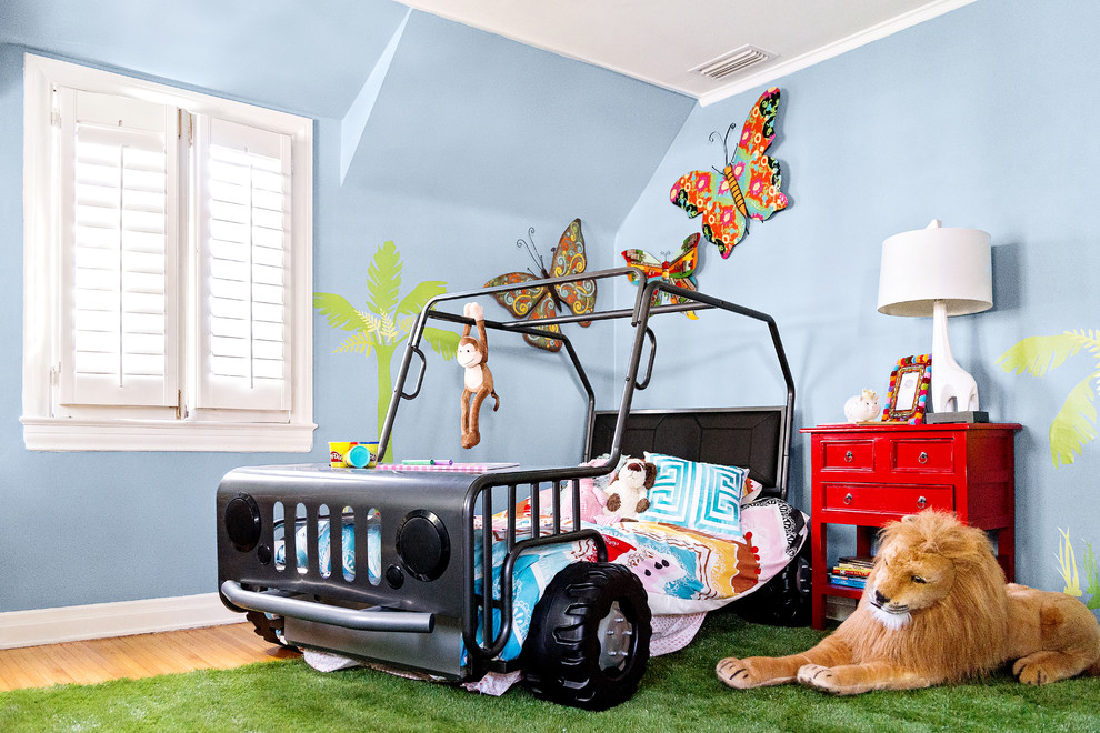 Foto di una cameretta per bambini da 1 a 3 anni tropicale di medie dimensioni con pareti blu e pavimento in legno massello medio
