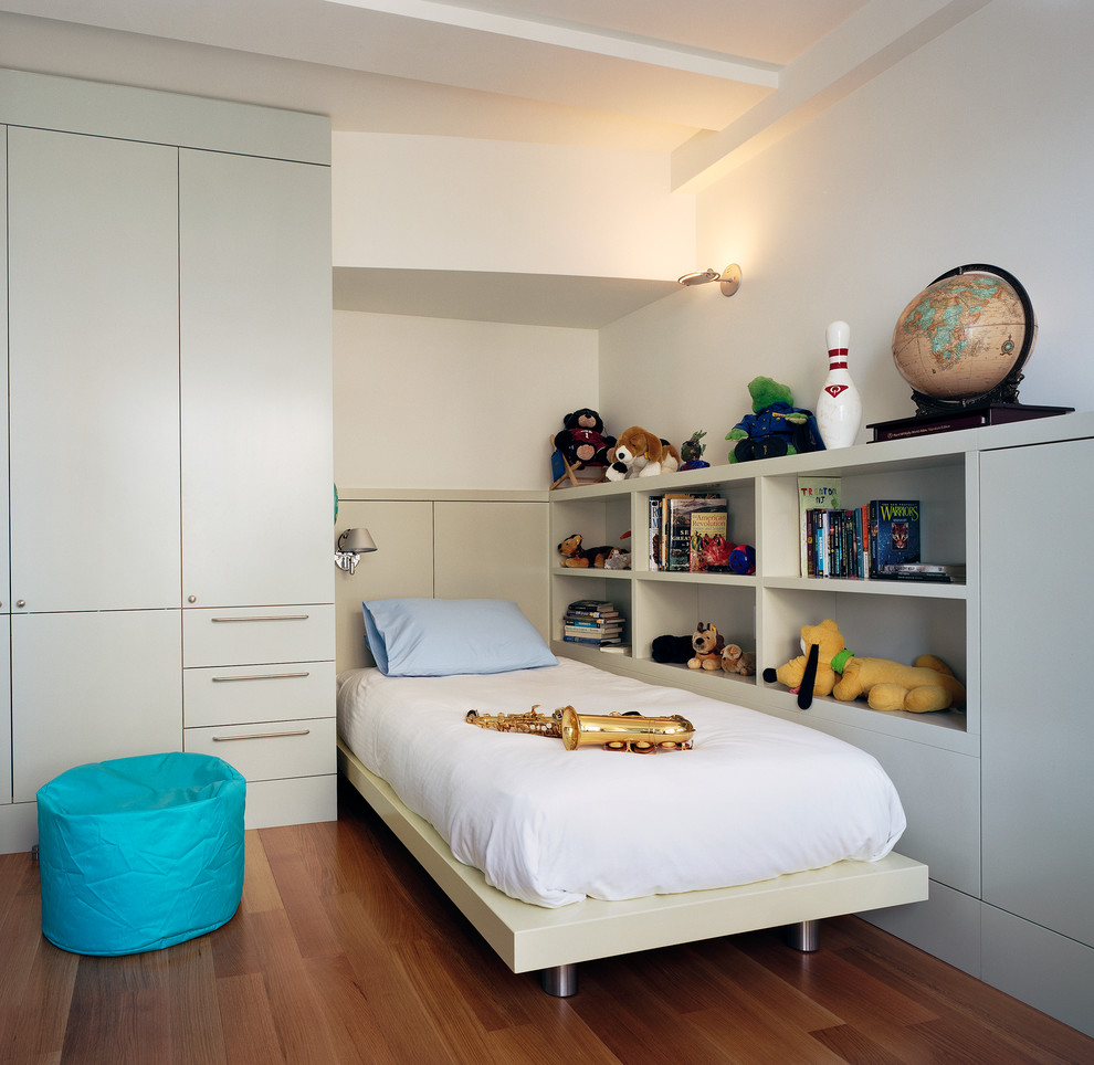 Cette image montre une petite chambre d'enfant design avec un mur blanc et parquet foncé.