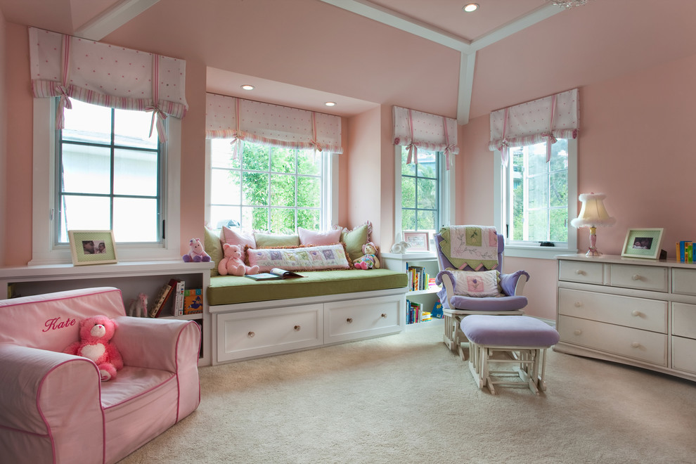 Inspiration for a classic toddler’s room for girls in San Diego with pink walls and carpet.