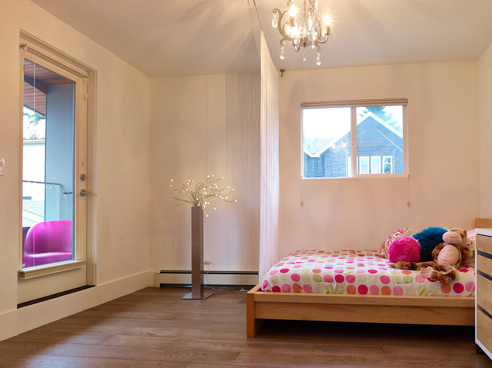 Modelo de dormitorio infantil de 4 a 10 años actual con paredes blancas y suelo de madera en tonos medios