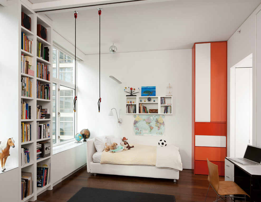 Example of a mid-sized trendy gender-neutral dark wood floor and brown floor kids' room design in New York with white walls