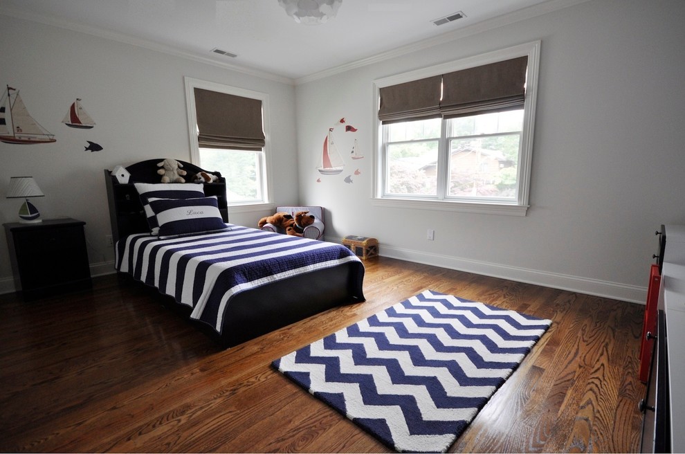 This is an example of a large contemporary children’s room for boys in New York with white walls and medium hardwood flooring.