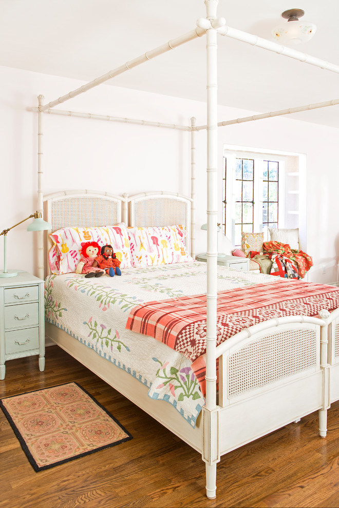 Kids' room - large country girl medium tone wood floor and brown floor kids' room idea in Los Angeles with pink walls