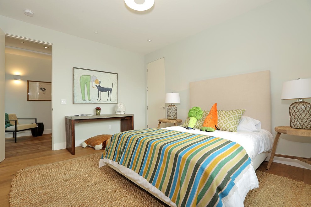Cette image montre une chambre d'enfant de 4 à 10 ans minimaliste de taille moyenne avec un mur gris et un sol en bois brun.