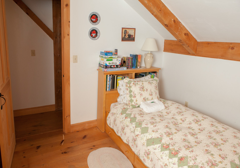 Immagine di una piccola cameretta per bambini country con pareti bianche e pavimento in legno massello medio