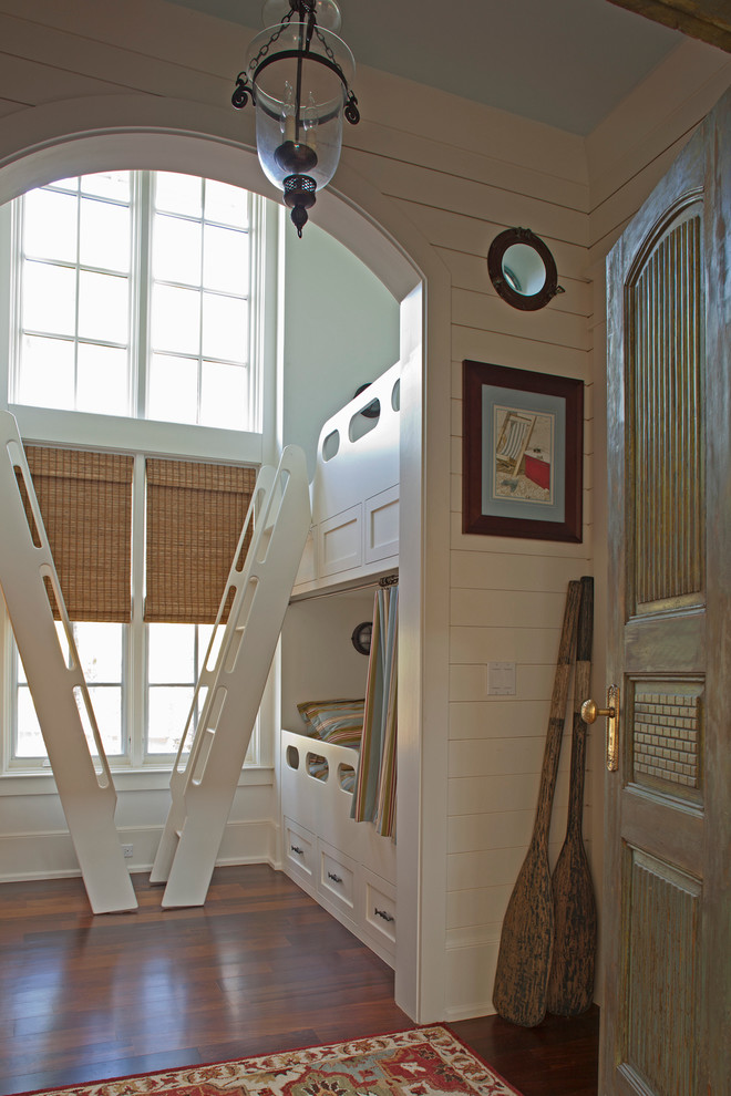 Exempel på ett maritimt könsneutralt småbarnsrum kombinerat med sovrum, med vita väggar och mörkt trägolv