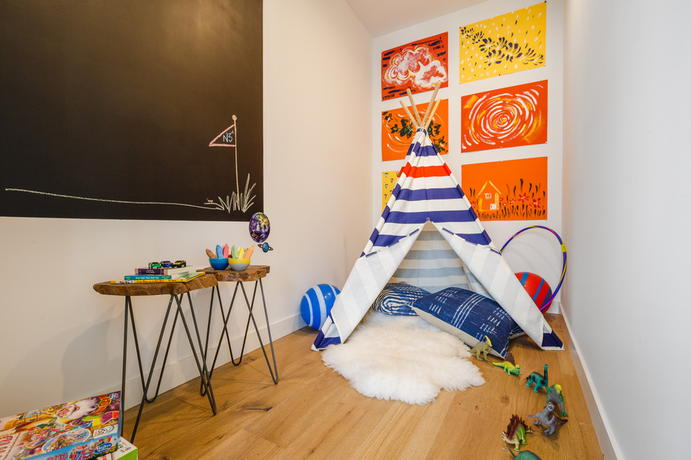 Cette photo montre une chambre d'enfant de 4 à 10 ans moderne de taille moyenne avec un mur blanc, parquet clair et un sol marron.