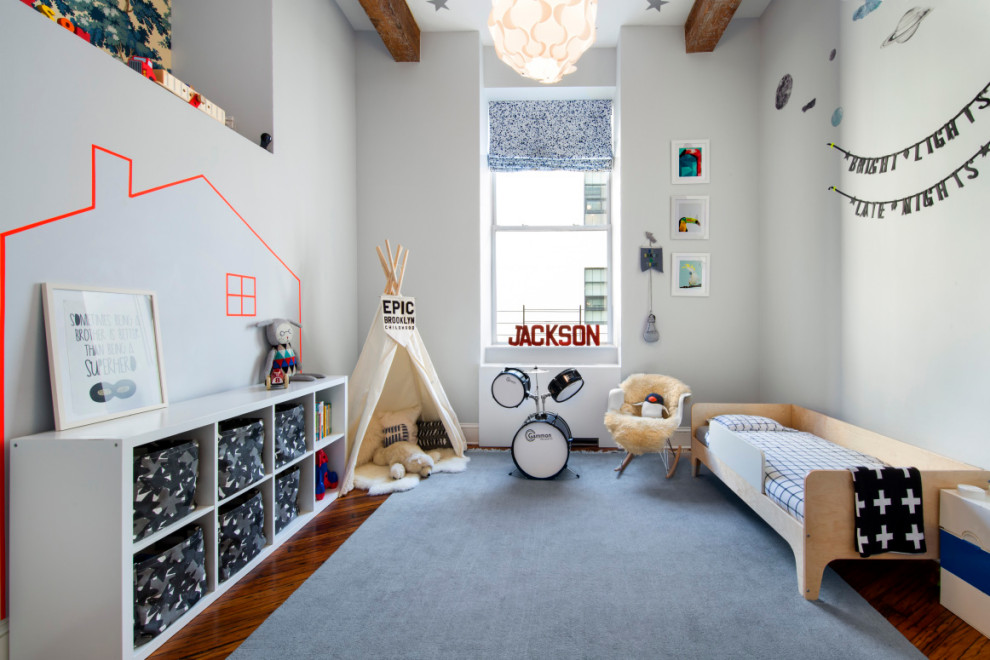 Inredning av ett klassiskt barnrum kombinerat med sovrum, med grå väggar och mellanmörkt trägolv
