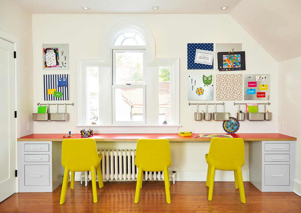 Bild på ett vintage könsneutralt barnrum kombinerat med skrivbord och för 4-10-åringar, med beige väggar och mellanmörkt trägolv