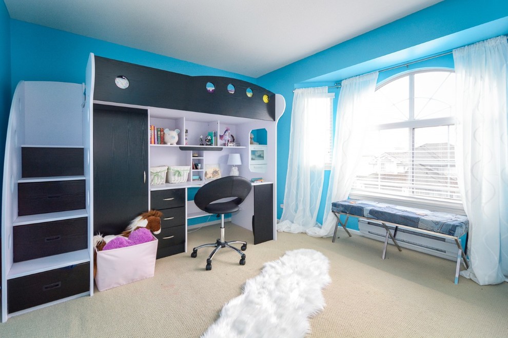 Modelo de dormitorio infantil contemporáneo de tamaño medio con escritorio, paredes azules, moqueta y suelo beige