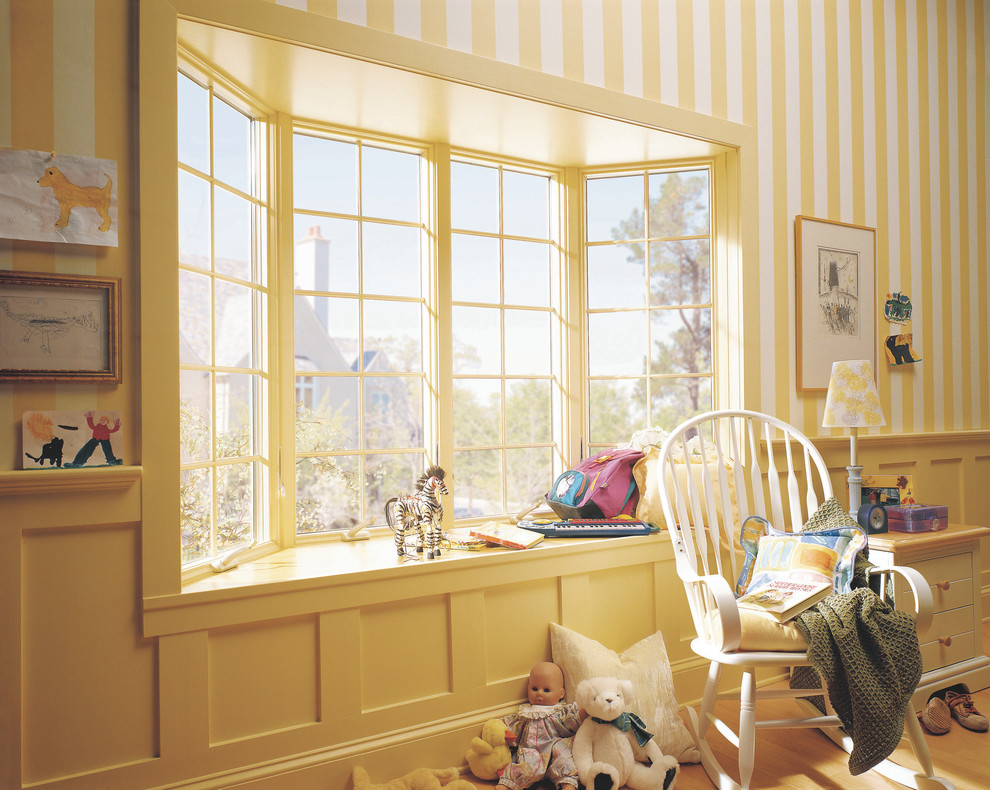 Ejemplo de dormitorio infantil de 1 a 3 años clásico de tamaño medio con paredes multicolor y suelo de madera clara