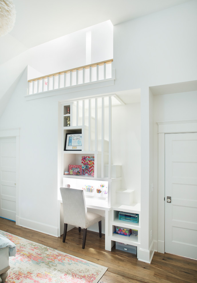 Idéer för ett klassiskt barnrum kombinerat med skrivbord, med vita väggar och mellanmörkt trägolv