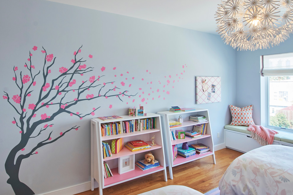Inspiration for a medium sized traditional children’s room for girls in New York with blue walls, medium hardwood flooring and brown floors.