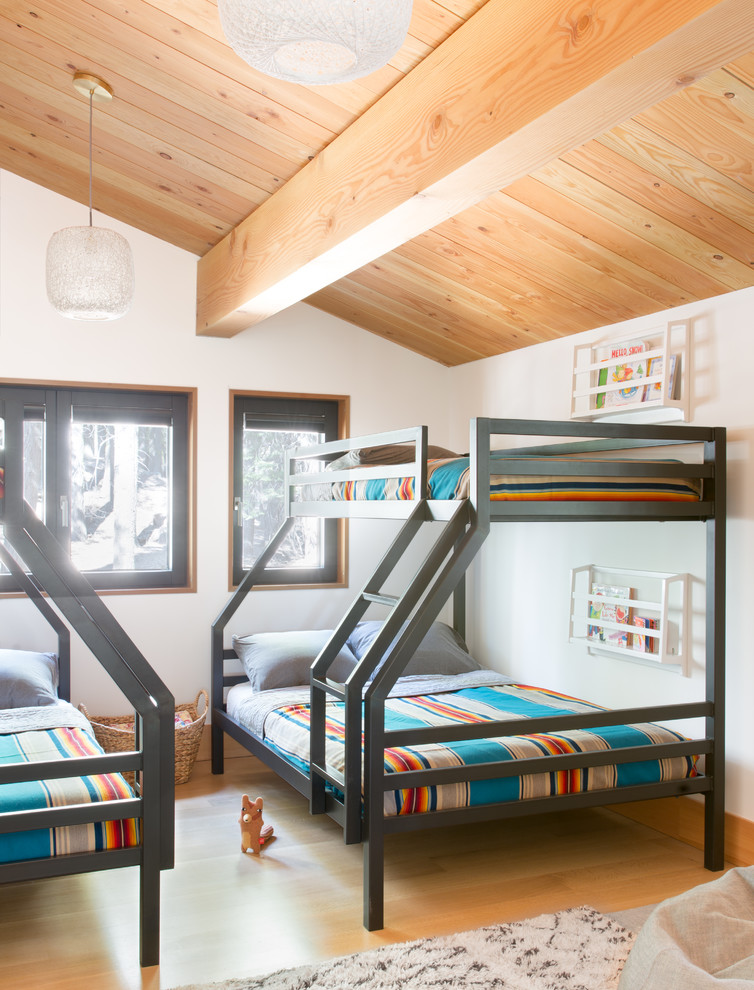 Bild på ett rustikt könsneutralt barnrum kombinerat med sovrum och för 4-10-åringar, med vita väggar och ljust trägolv