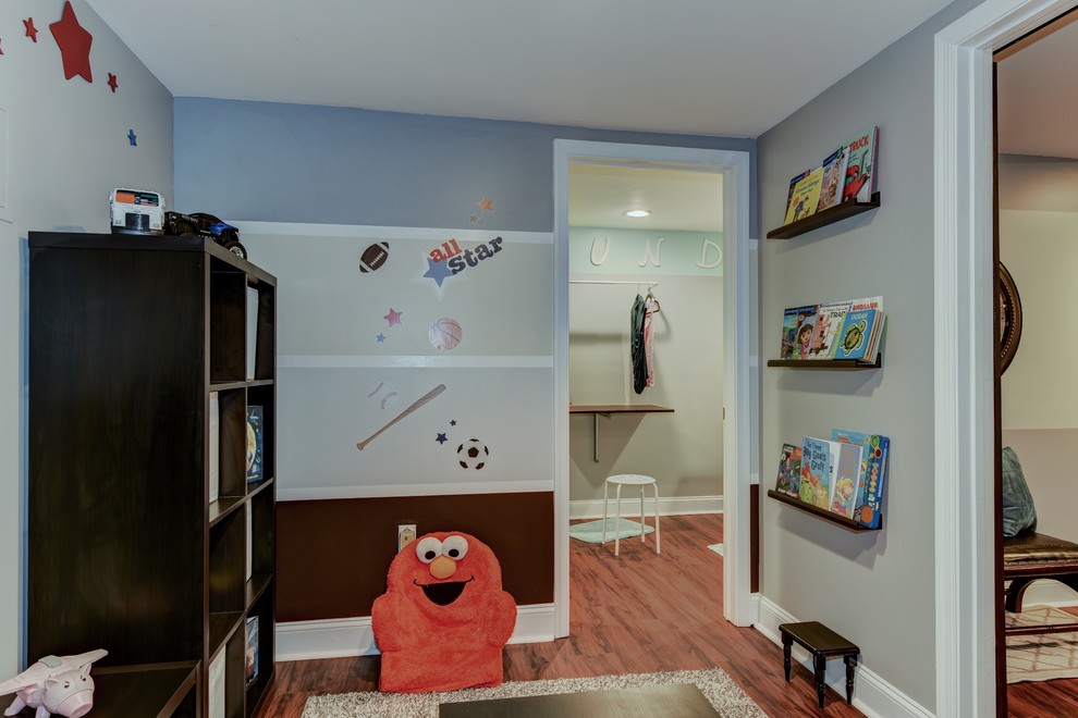 Foto di una piccola cameretta per bambini da 1 a 3 anni chic con pareti multicolore e pavimento in legno massello medio