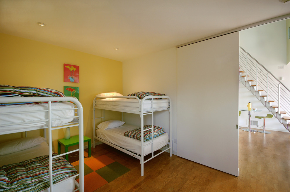 Cette image montre une chambre d'enfant design avec un sol en liège, un mur multicolore et un lit superposé.
