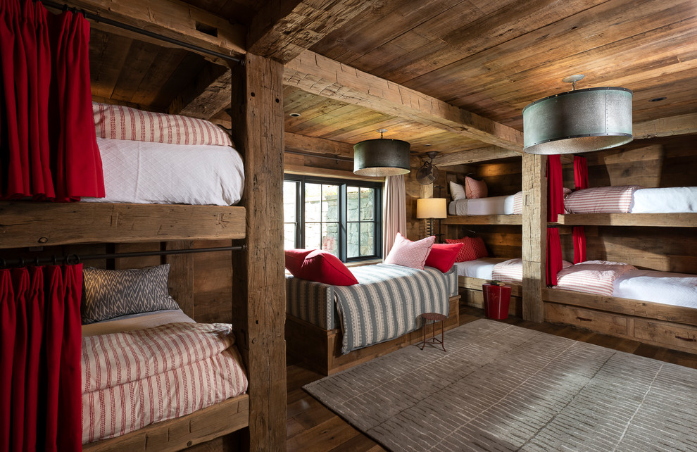 Exemple d'une grande chambre d'enfant montagne avec un sol marron, un mur marron, parquet foncé et un lit superposé.