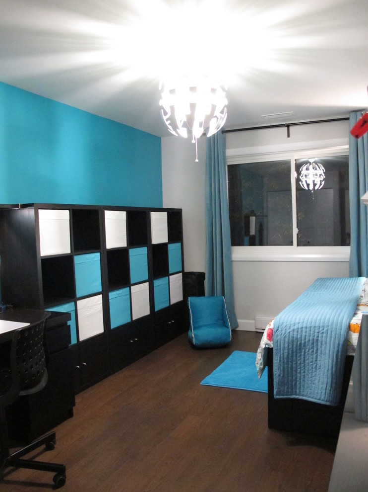 Idée de décoration pour une chambre d'enfant de 4 à 10 ans design de taille moyenne avec un mur bleu, parquet foncé et un sol marron.